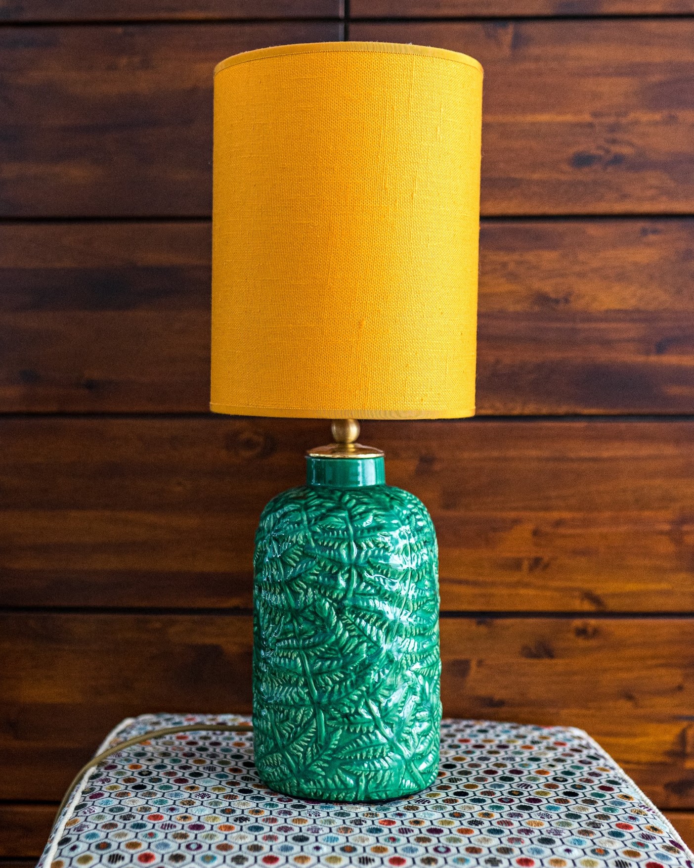Lampe mit gelbem Schirm auf grünem Keramikfuß